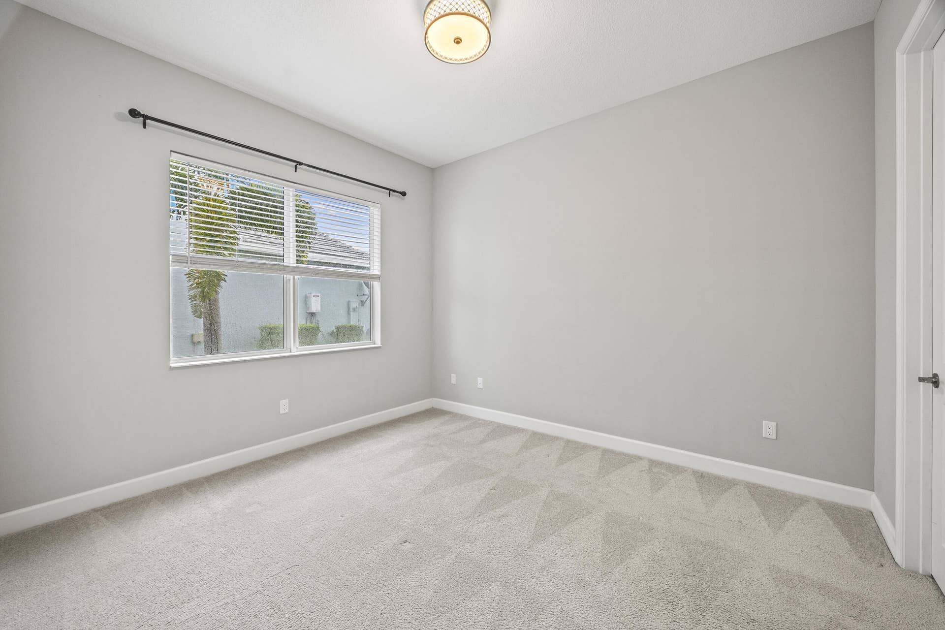 16007 Whippoorwill Circle, Westlake, Westlake, FL 33470 Neutral-toned carpeting, ample window with blinds, ceiling-mounted light fixture, and a white interior door with dark hardware