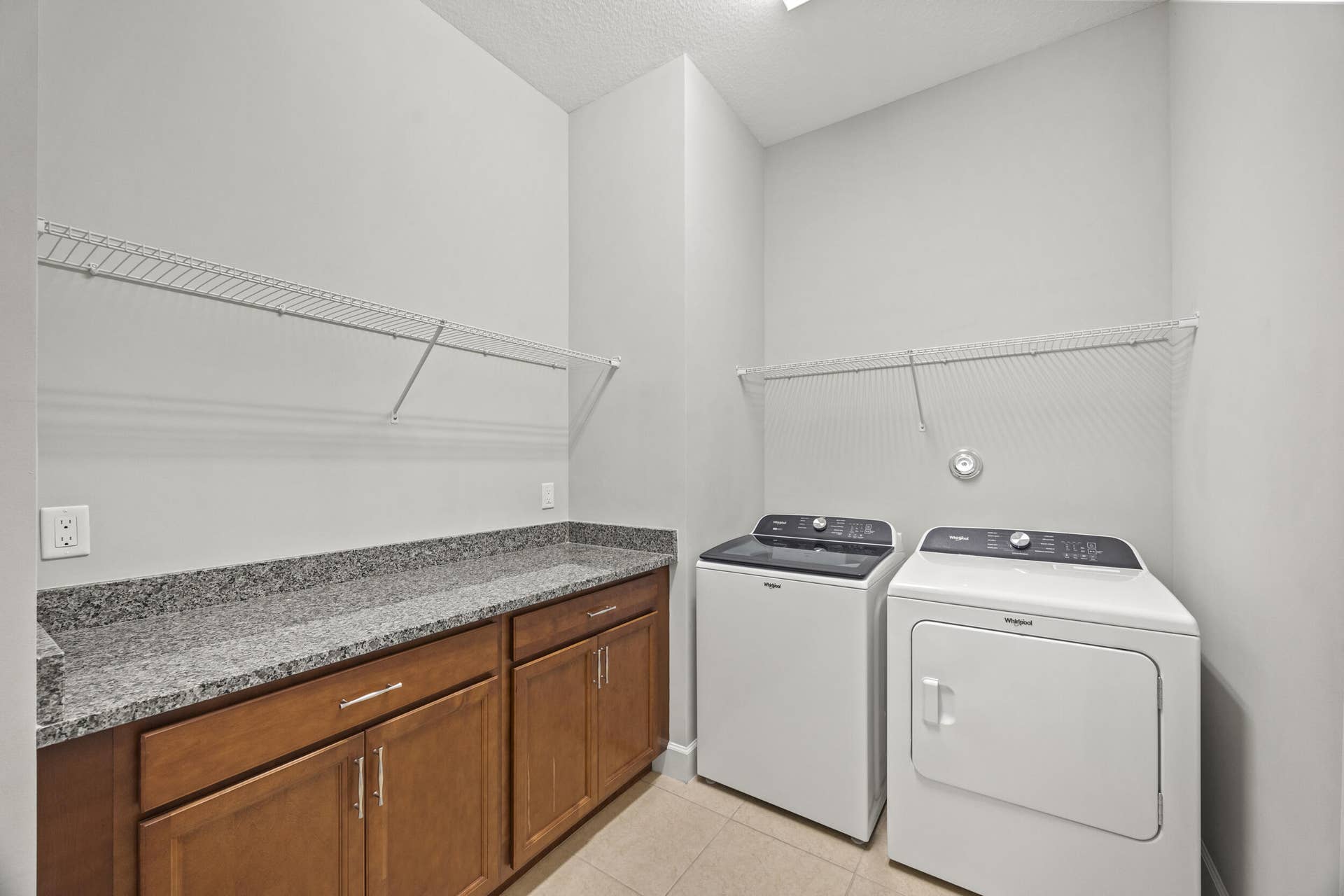 16007 Whippoorwill Circle, Westlake, Westlake, FL 33470 Laundry area featuring built-in cabinetry, granite-finish countertop, and wire shelving