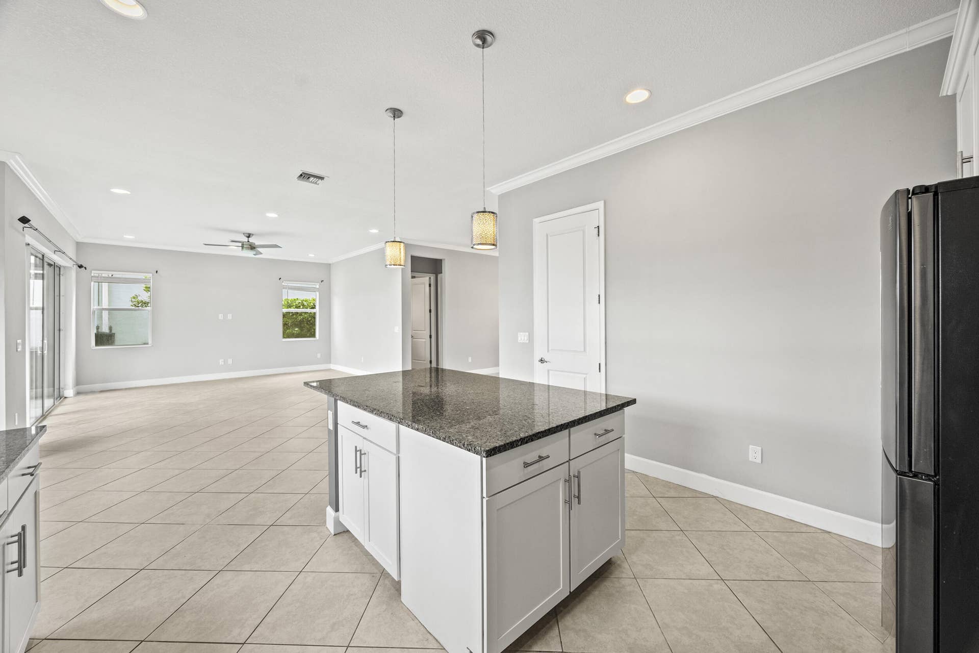 16007 Whippoorwill Circle, Westlake, Westlake, FL 33470 Open-concept living space featuring a kitchen island with stone countertop, tile flooring, and recessed lighting
