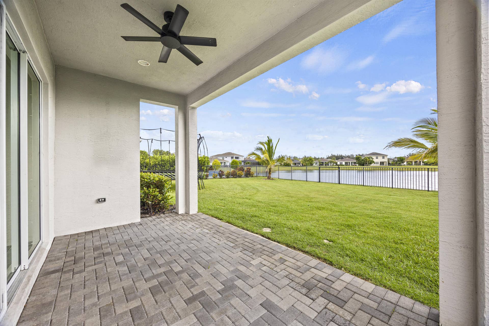 16007 Whippoorwill Circle, Westlake, Westlake, FL 33470 Covered patio with paver flooring, overhead ceiling fan, and sliding glass doors