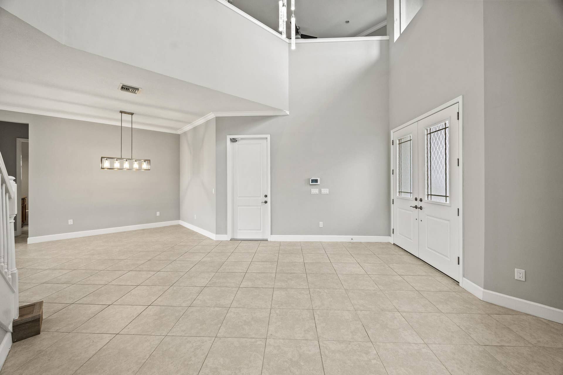 16007 Whippoorwill Circle, Westlake, Westlake, FL 33470 Two-story foyer with a double-door entry, tiled flooring, and a linear chandelier