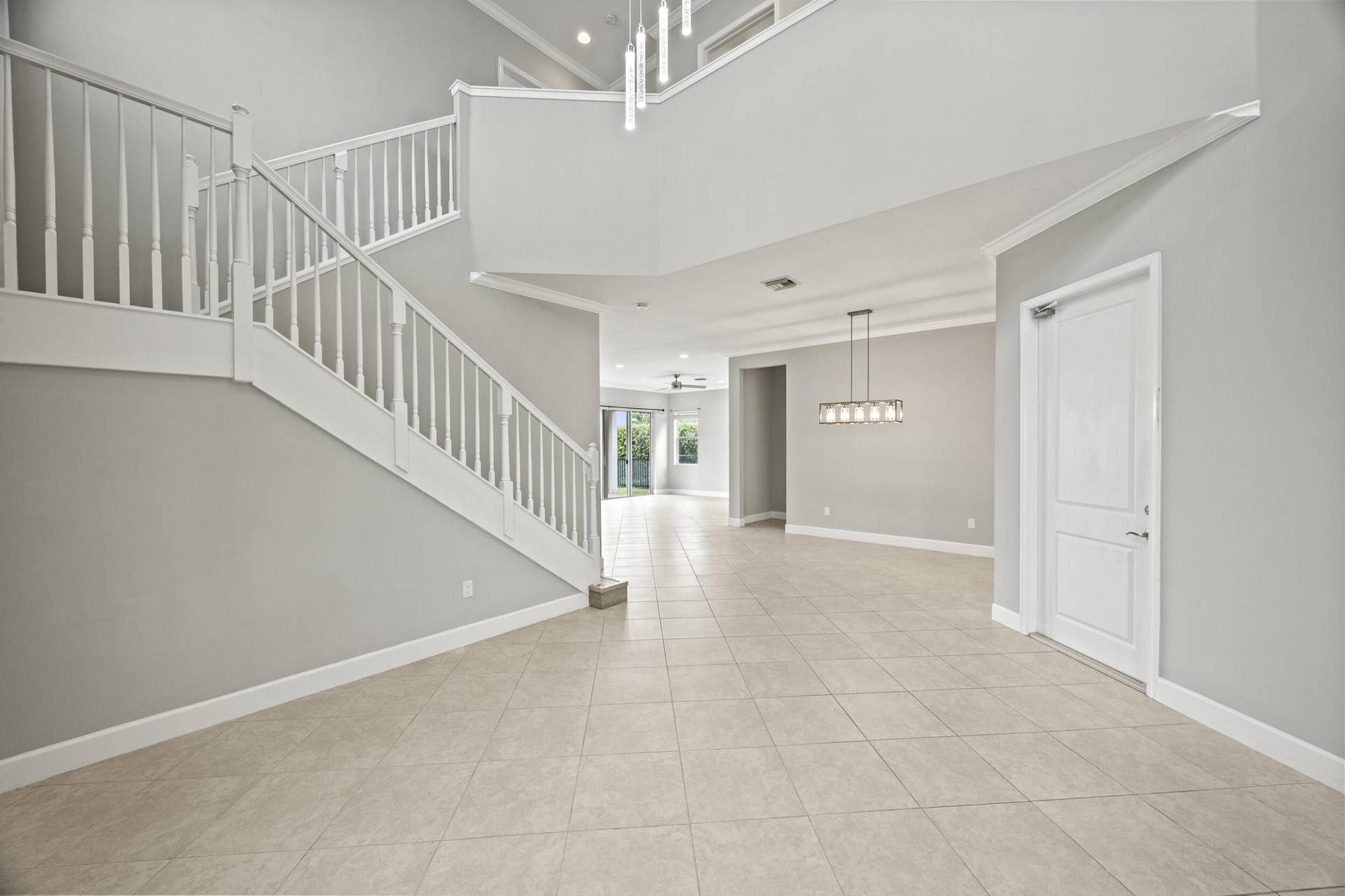 16007 Whippoorwill Circle, Westlake, Westlake, FL 33470 Foyer with tile flooring, white staircase with balusters, and a contemporary chandelier