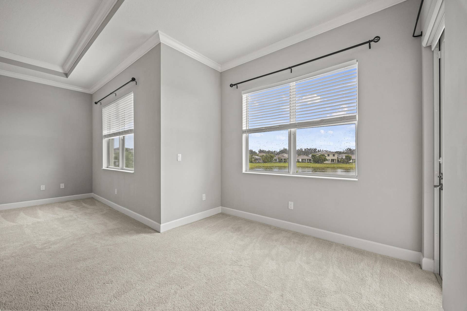 16007 Whippoorwill Circle, Westlake, Westlake, FL 33470 Tray ceiling, crown molding, double window, light carpeting, and a glass-paneled door