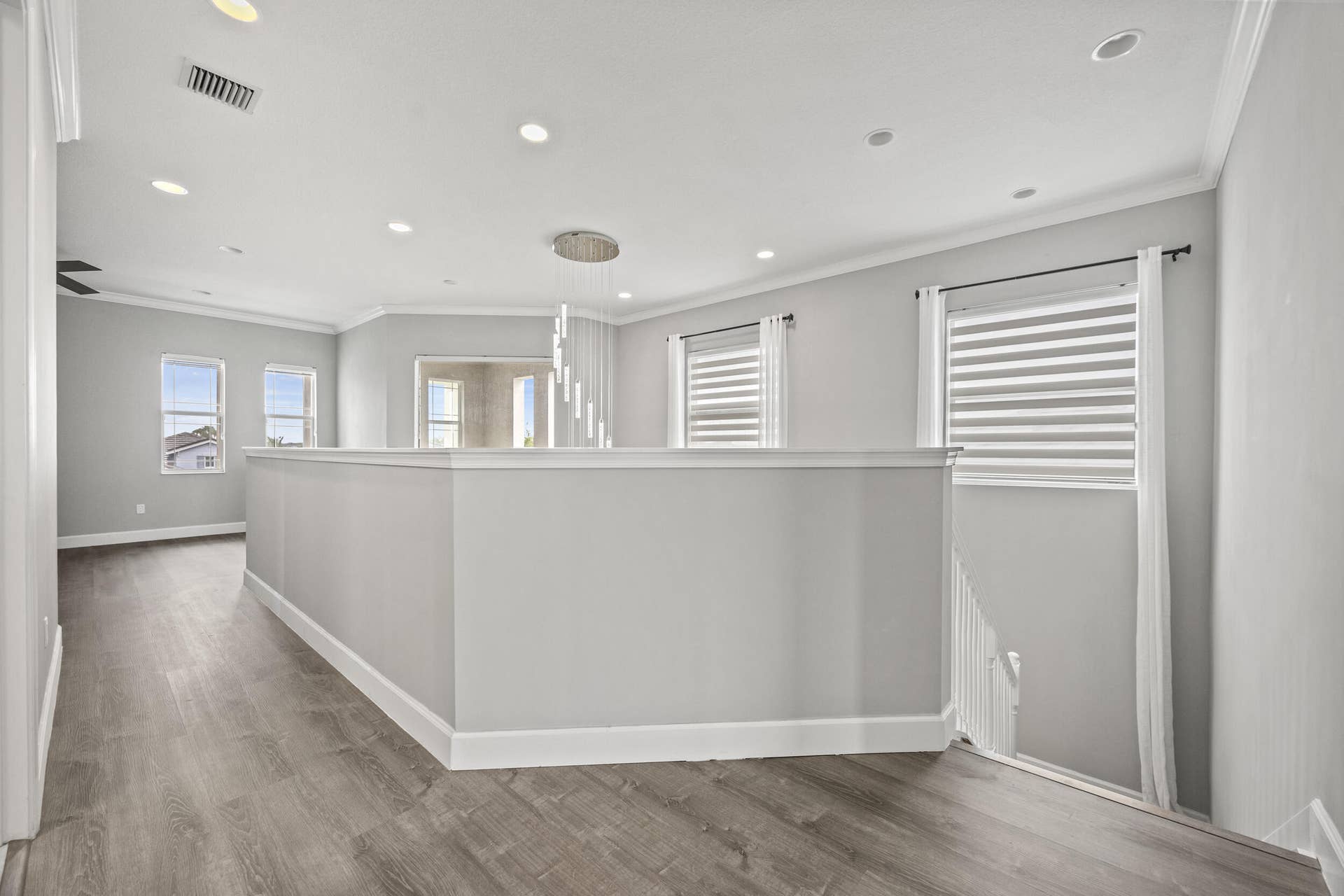16007 Whippoorwill Circle, Westlake, Westlake, FL 33470 Wood-finish flooring, recessed lighting, crown molding, and multiple windows with blinds