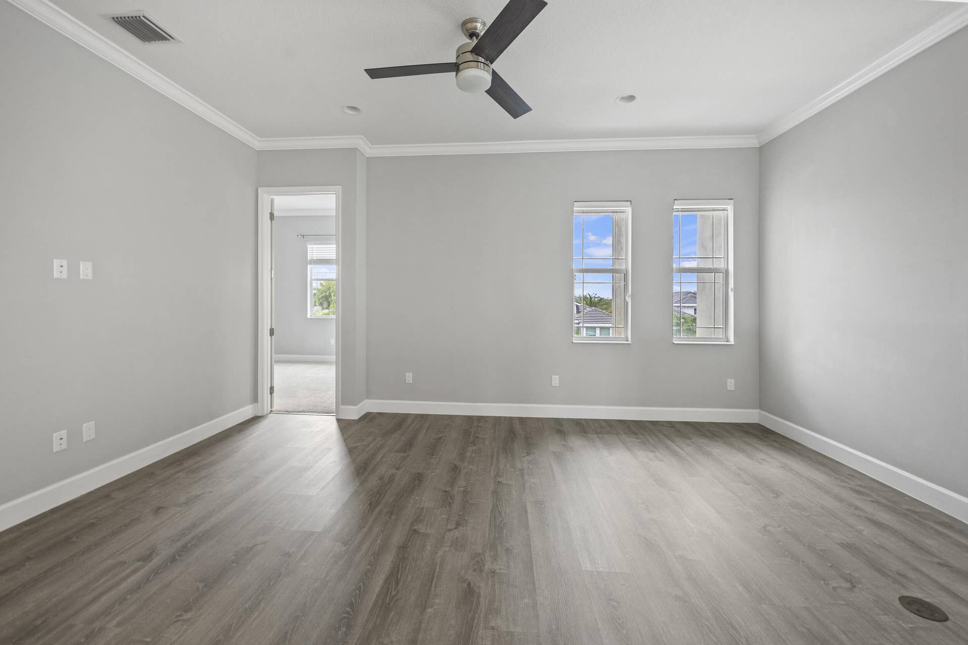 16007 Whippoorwill Circle, Westlake, Westlake, FL 33470 Spacious room featuring wood-finish flooring, light gray wall paint, white crown molding, and an attached ceiling fan
