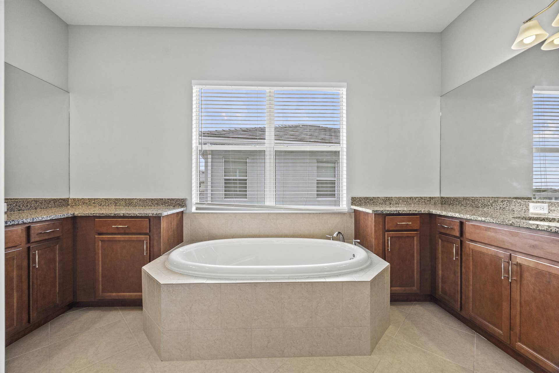 16007 Whippoorwill Circle, Westlake, Westlake, FL 33470 Built-in soaking tub with tiled surround, dual wood-finish vanity cabinets, and speckled countertops