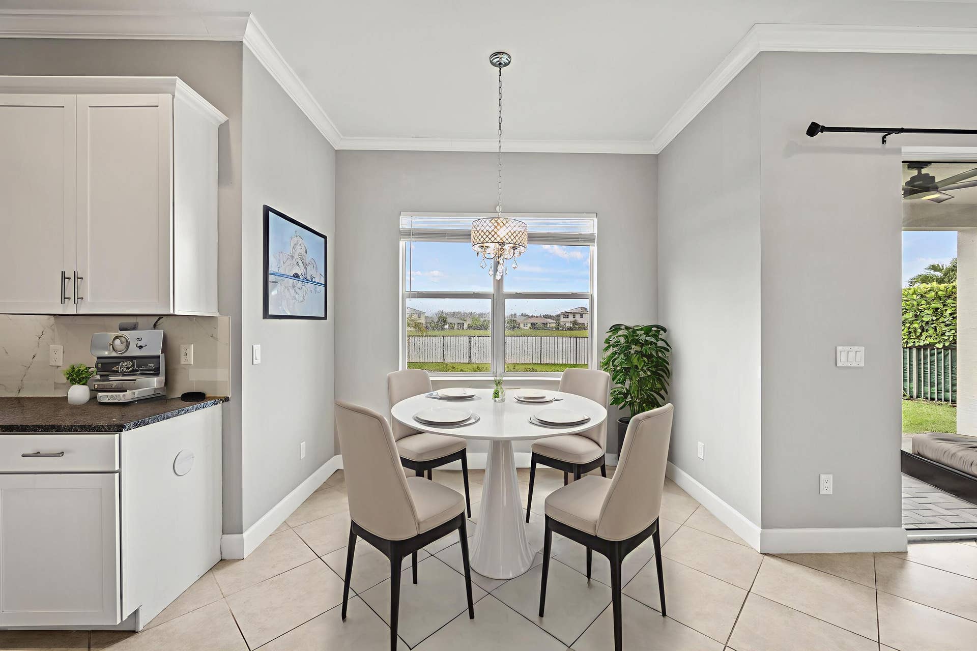 16007 Whippoorwill Circle, Westlake, Westlake, FL 33470 Kitchenette featuring white cabinetry, dark countertop, tile flooring, and a crystal chandelier