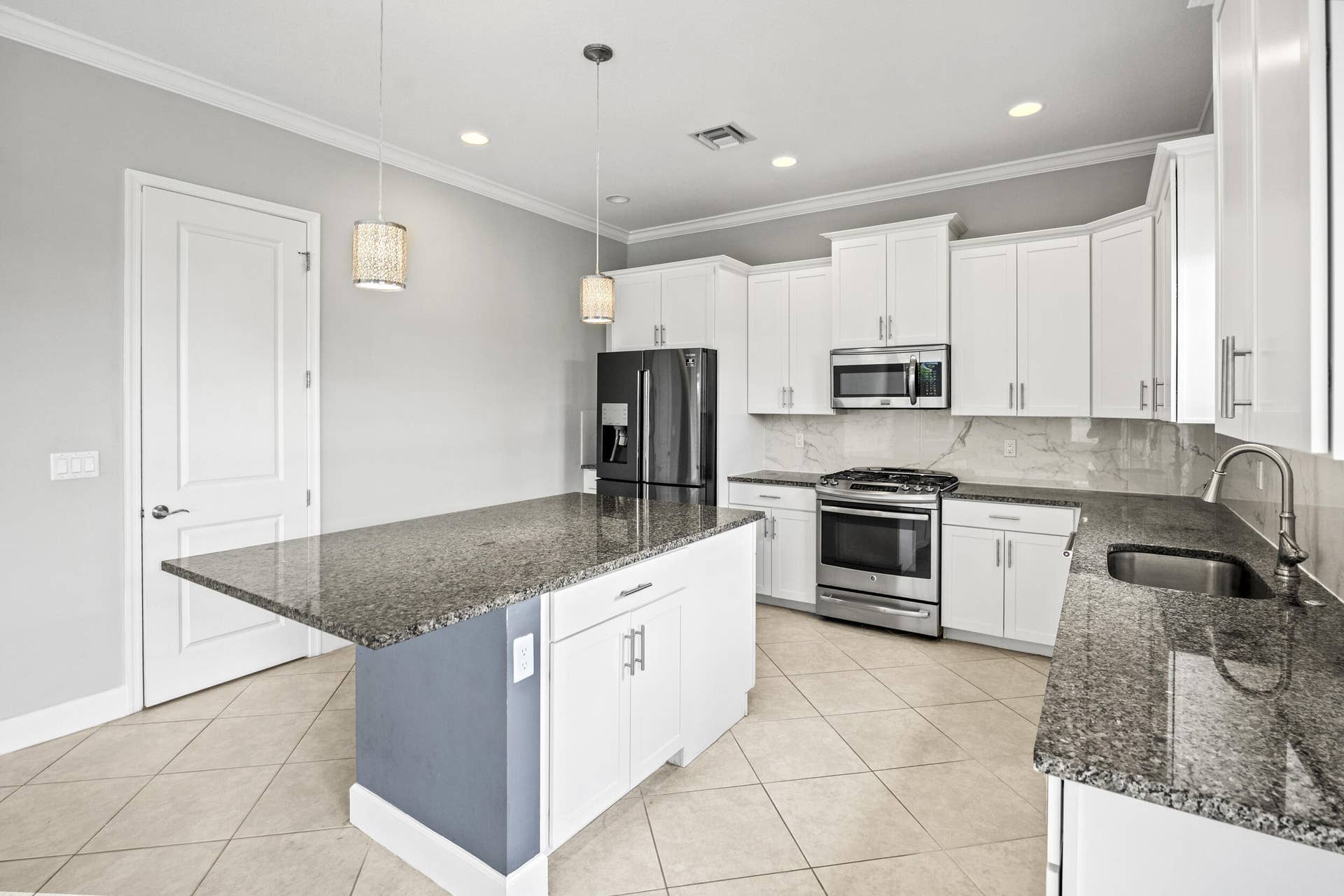 16007 Whippoorwill Circle, Westlake, Westlake, FL 33470 Kitchen featuring a central island with countertop, stainless steel appliances, white cabinetry, and tile flooring