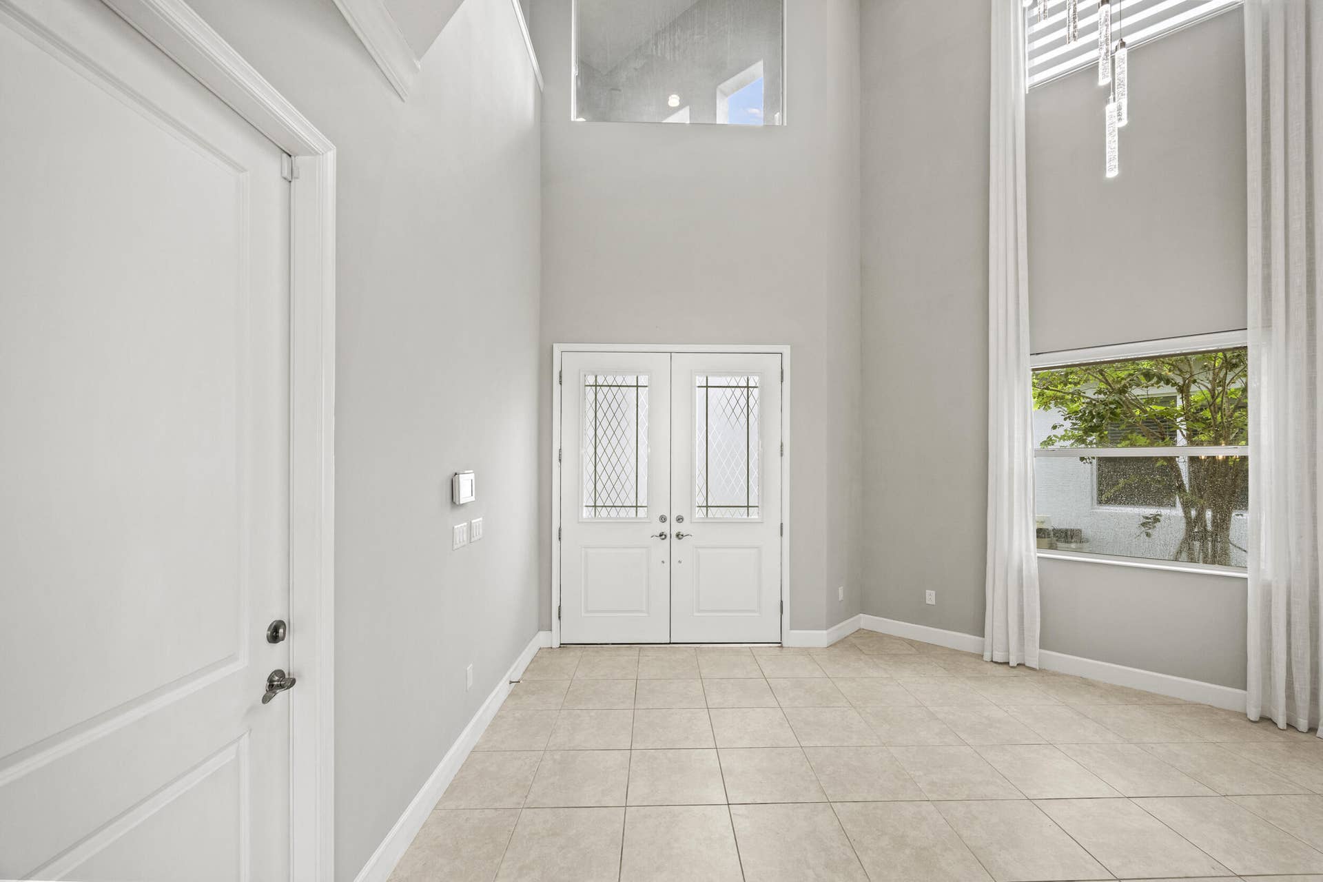 16007 Whippoorwill Circle, Westlake, Westlake, FL 33470 Grand entry with double front doors featuring decorative glass inserts, soaring ceilings, and a tall window