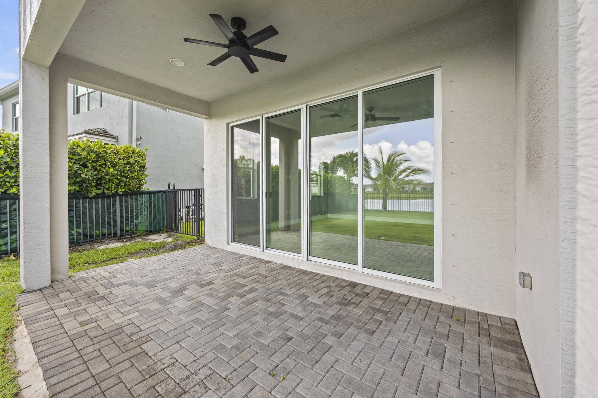 16007 Whippoorwill Circle, Westlake, Westlake, FL 33470 Covered patio with paver flooring, overhead fan, and large sliding glass doors