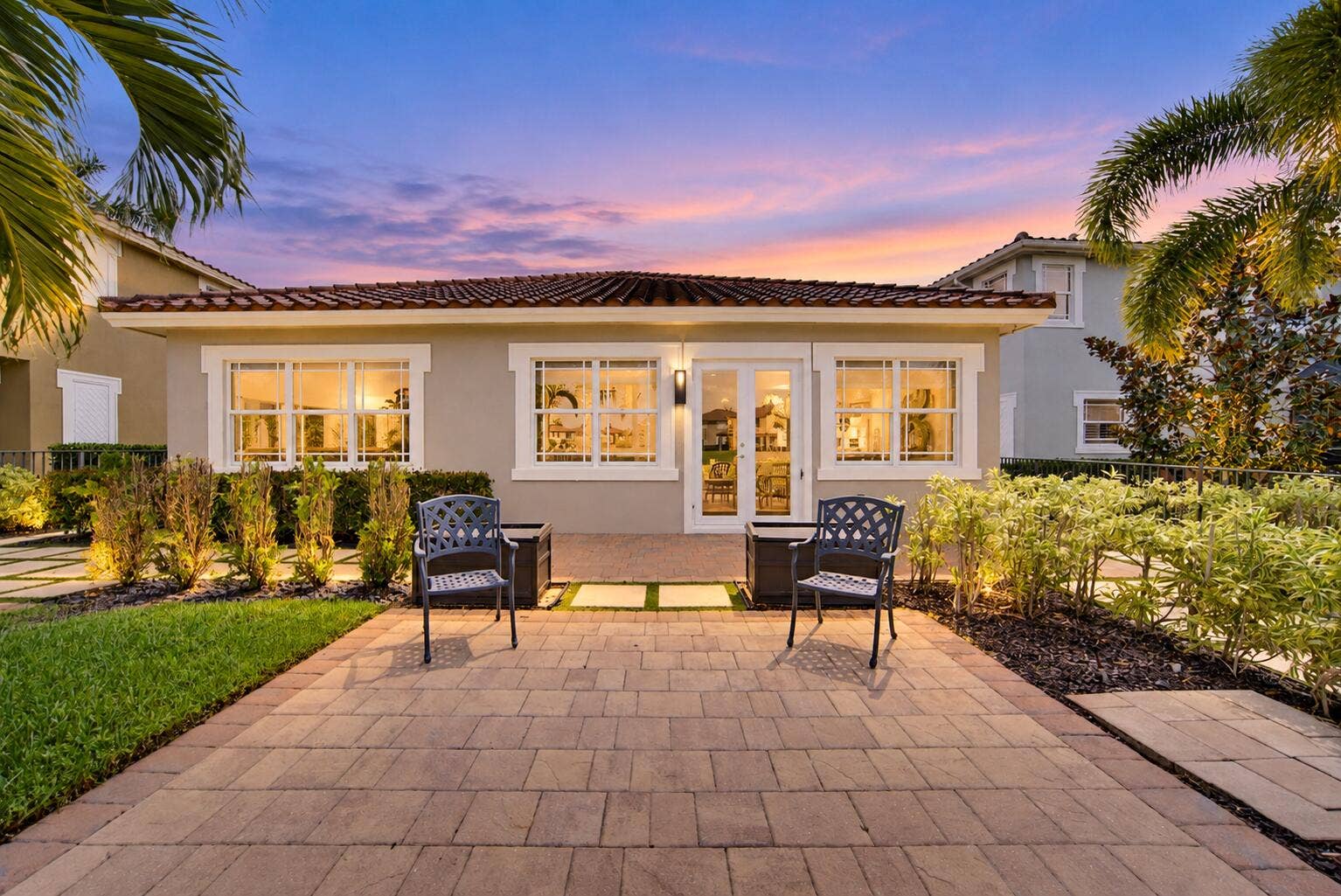 8561 LAKESIDE Bend, Parkland, FL 33076 Twilight Patio with Palm-Framed Home