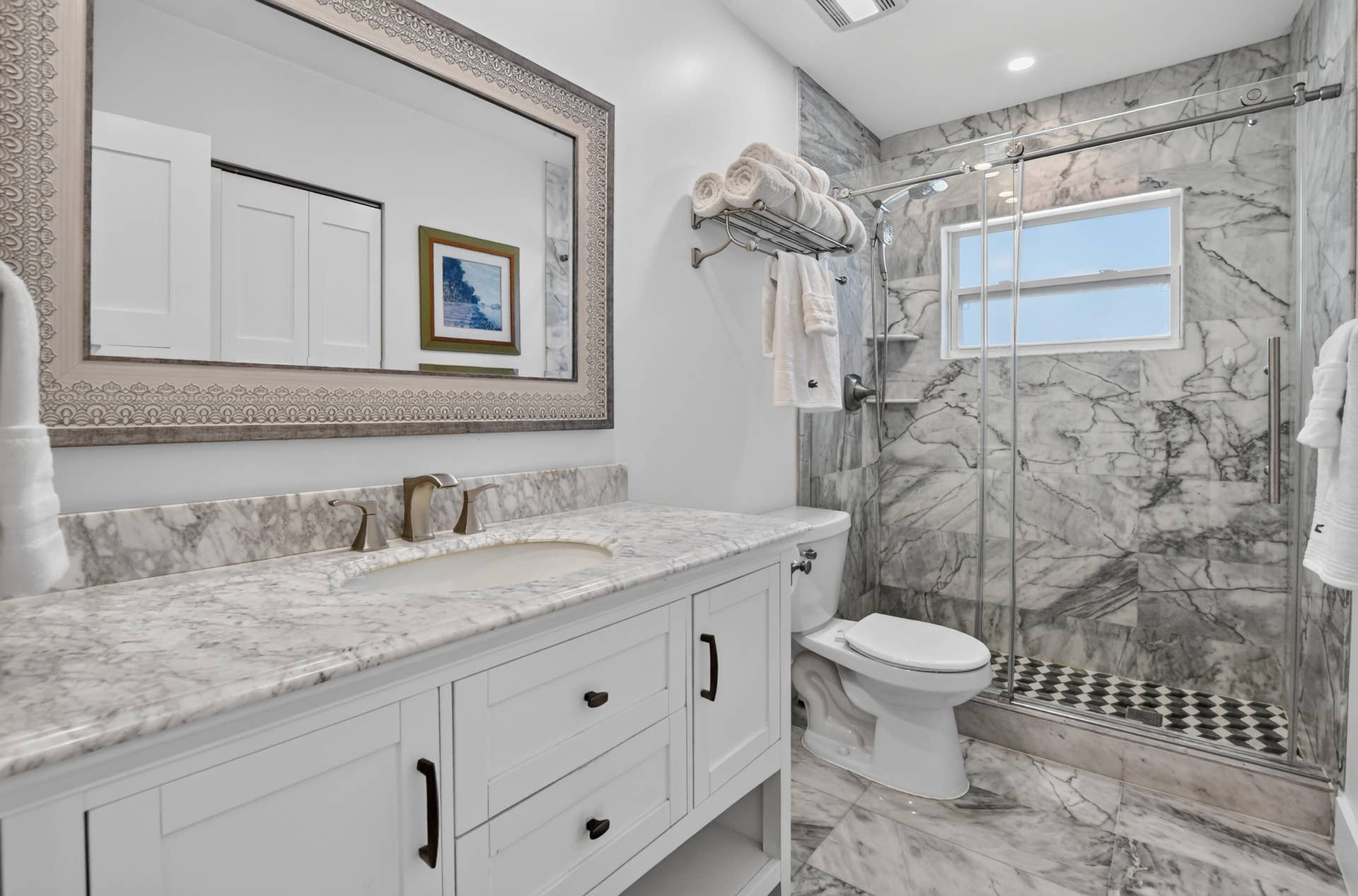Main bathroom features marble floors, counters and shower