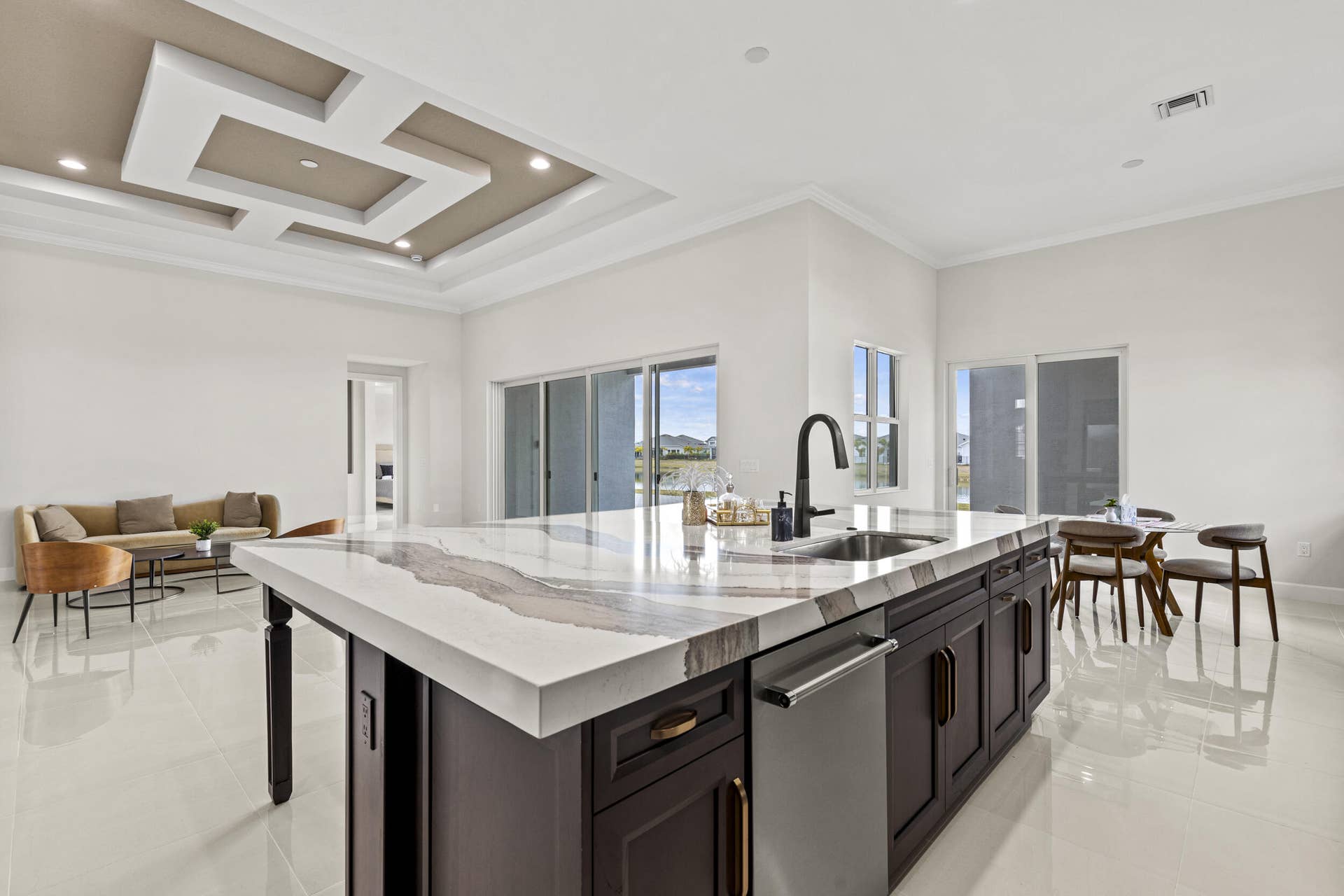 14976 Woodlot Court, Westlake, FL 33470 Kitchen island with a waterfall countertop, integrated sink, and matte black faucet