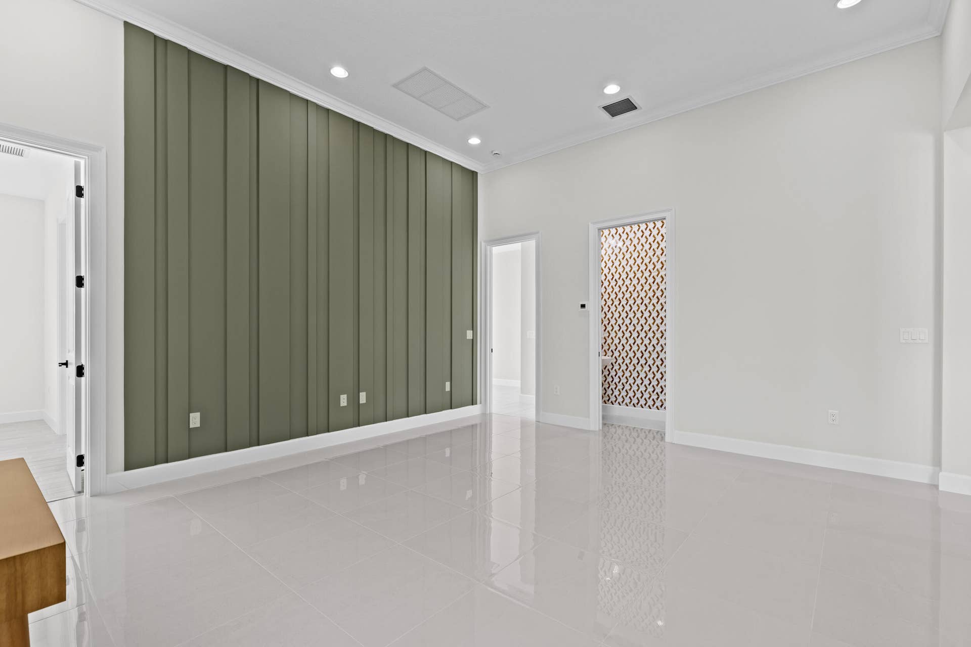 14976 Woodlot Court, Westlake, FL 33470 Flex Room with expansive interior space featuring a paneled accent wall, recessed lighting, white tile flooring, and a decorative frosted glass door