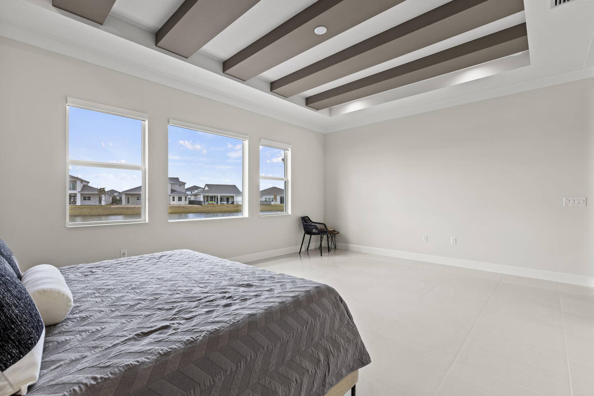 14976 Woodlot Court, Westlake, FL 33470 Owner's Suite featuring tray ceiling with recessed lighting and decorative beams