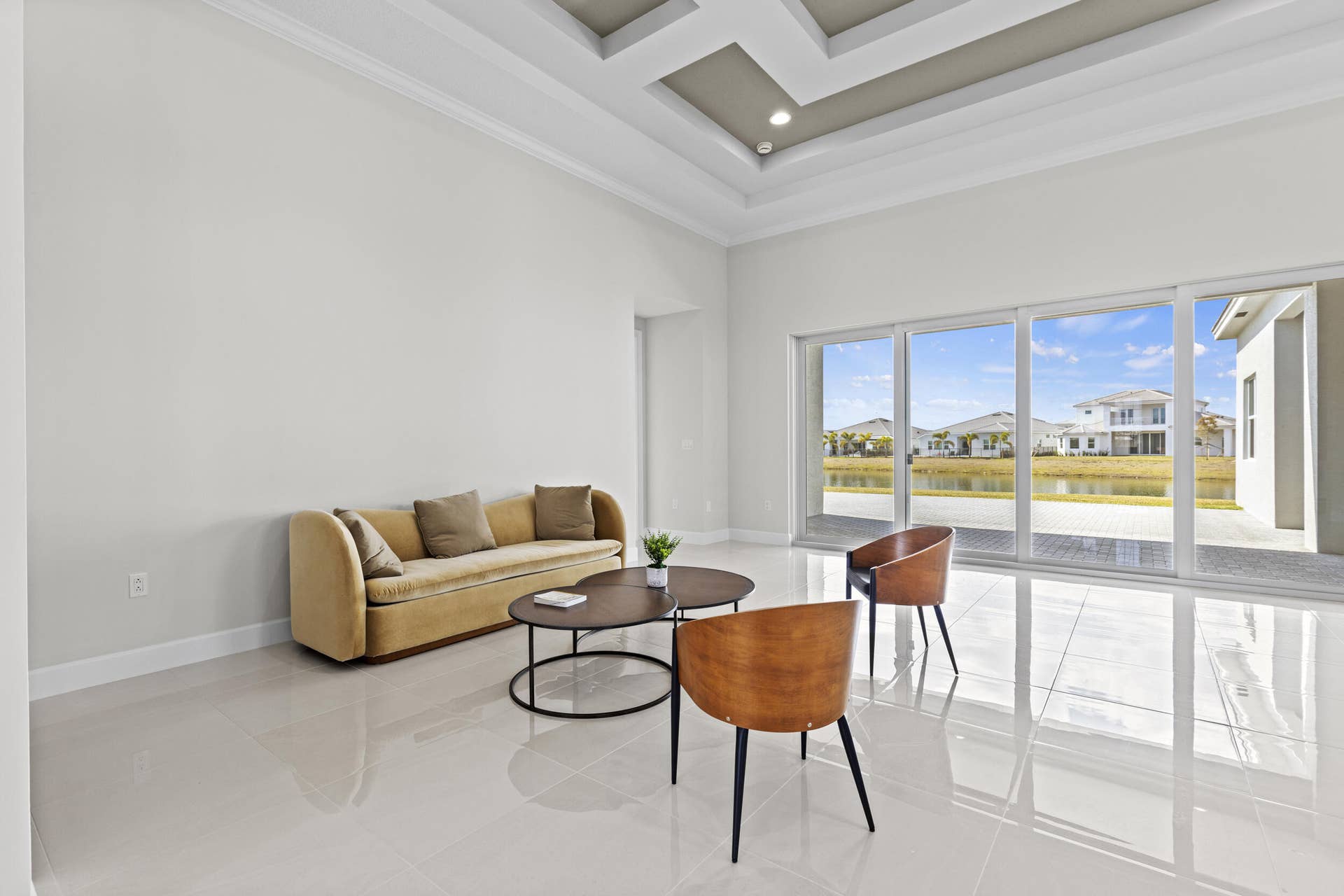 14976 Woodlot Court, Westlake, FL 33470 Tray ceiling with recessed lighting, large format tile flooring, and expansive sliding glass doors opening to a patio
