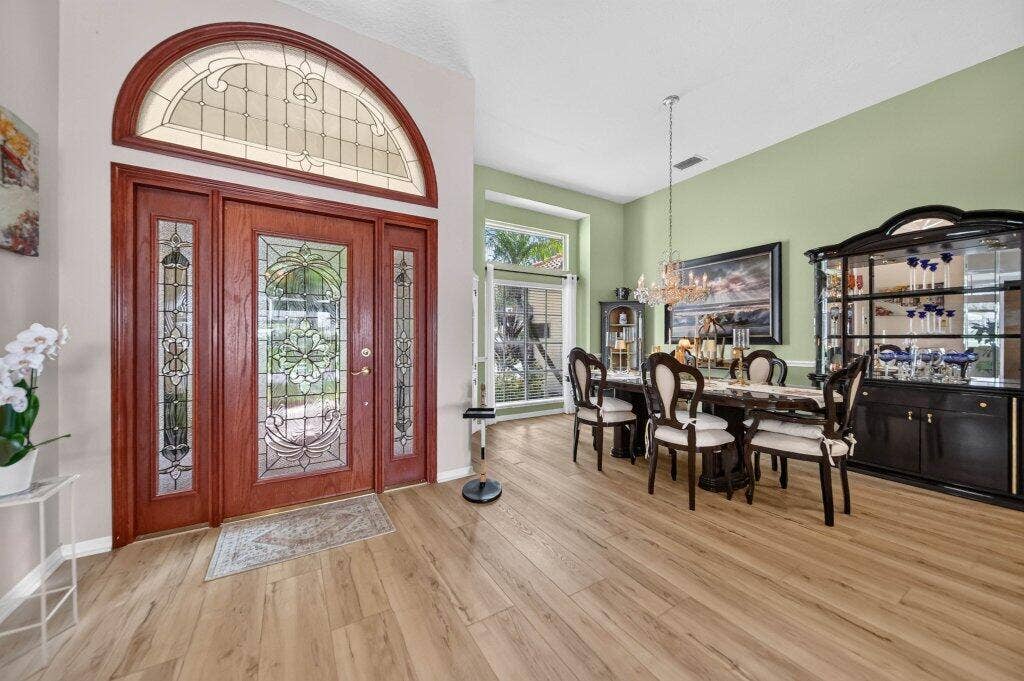 Wood-finish flooring throughout, framed by a CUSTOM door entry with sidelights and an arched transom window