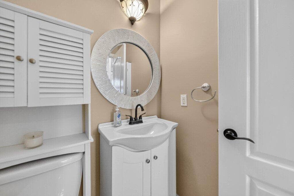 White vanity with integrated sink, oil-rubbed bronze faucet. Convenient for dinner guests!