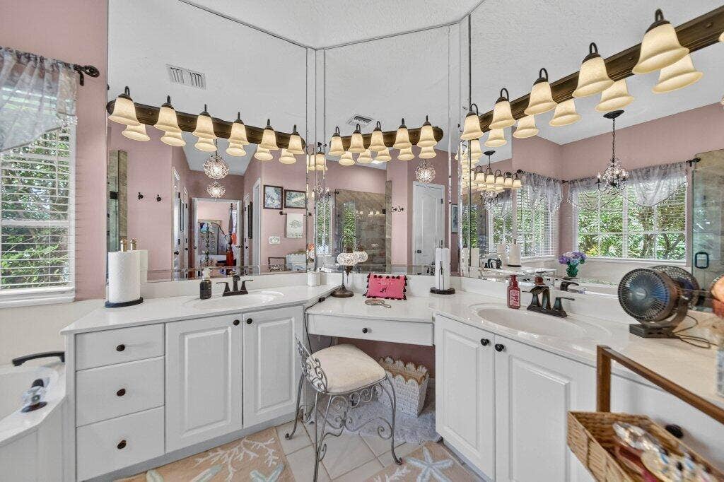 Dual white vanities with integrated sinks, white countertops, and white cabinetry