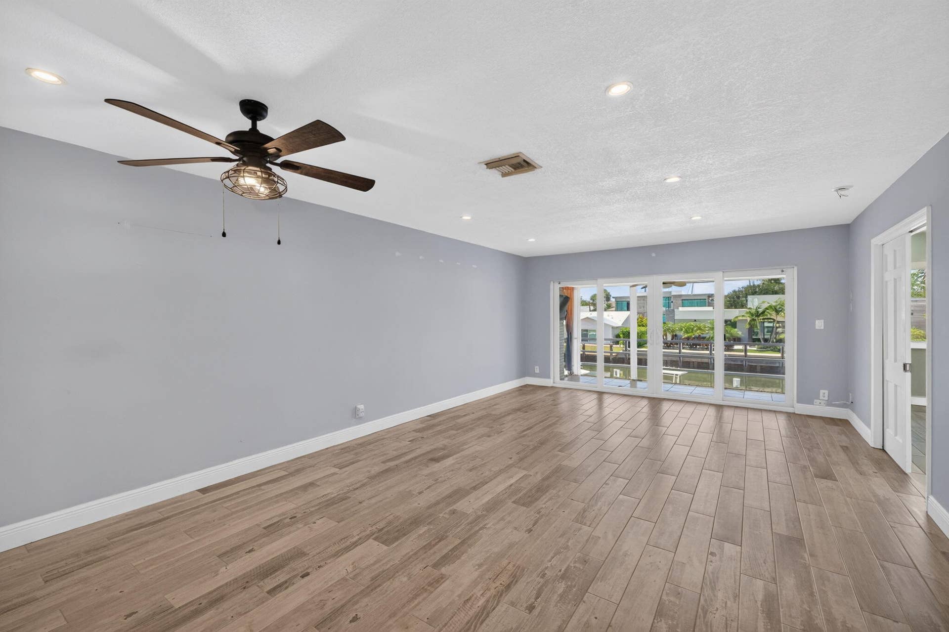 Wood-finish flooring, recessed lighting, and a ceiling fan with integrated lighting