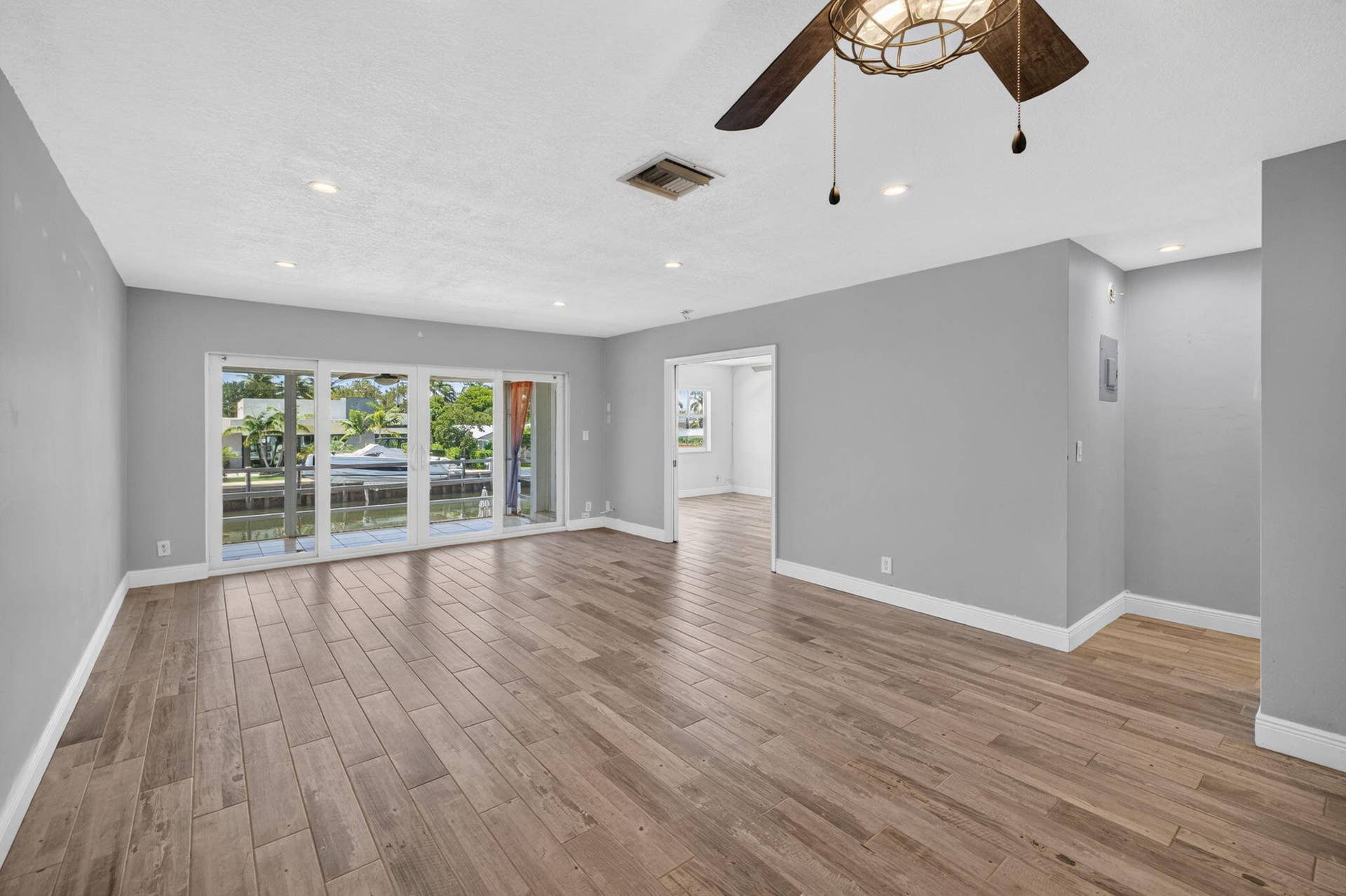 Wood-finish flooring throughout, recessed lighting, and a ceiling fan with integrated light