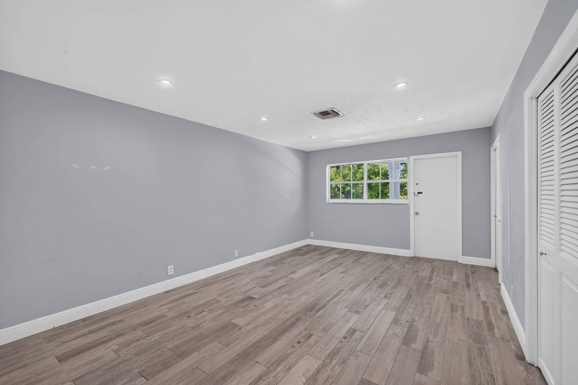 Wood-finish flooring, recessed lighting, and a window with exterior views