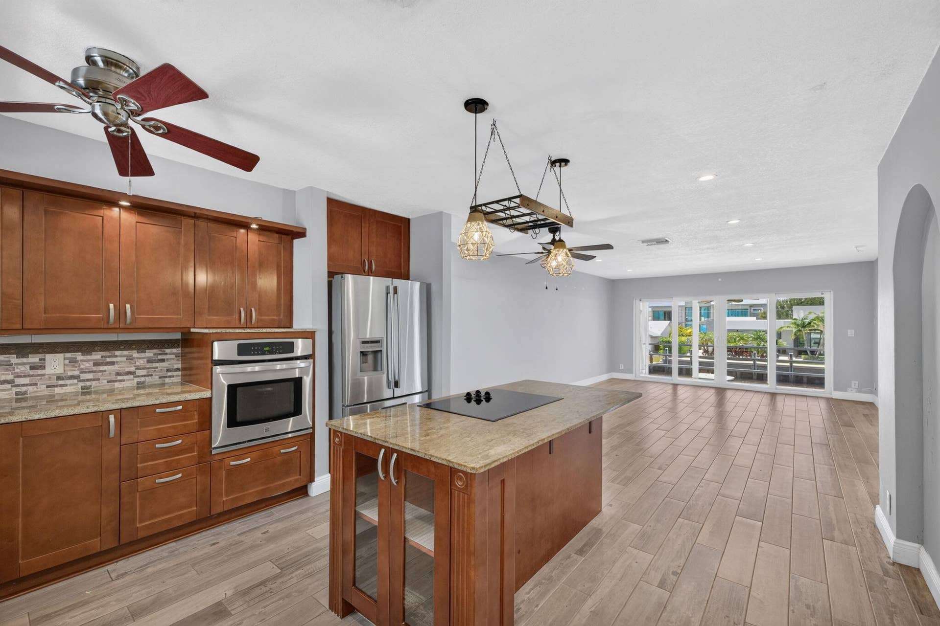 Kitchen with wood-finish cabinetry, stainless steel appliances, and a mosaic tile backsplash