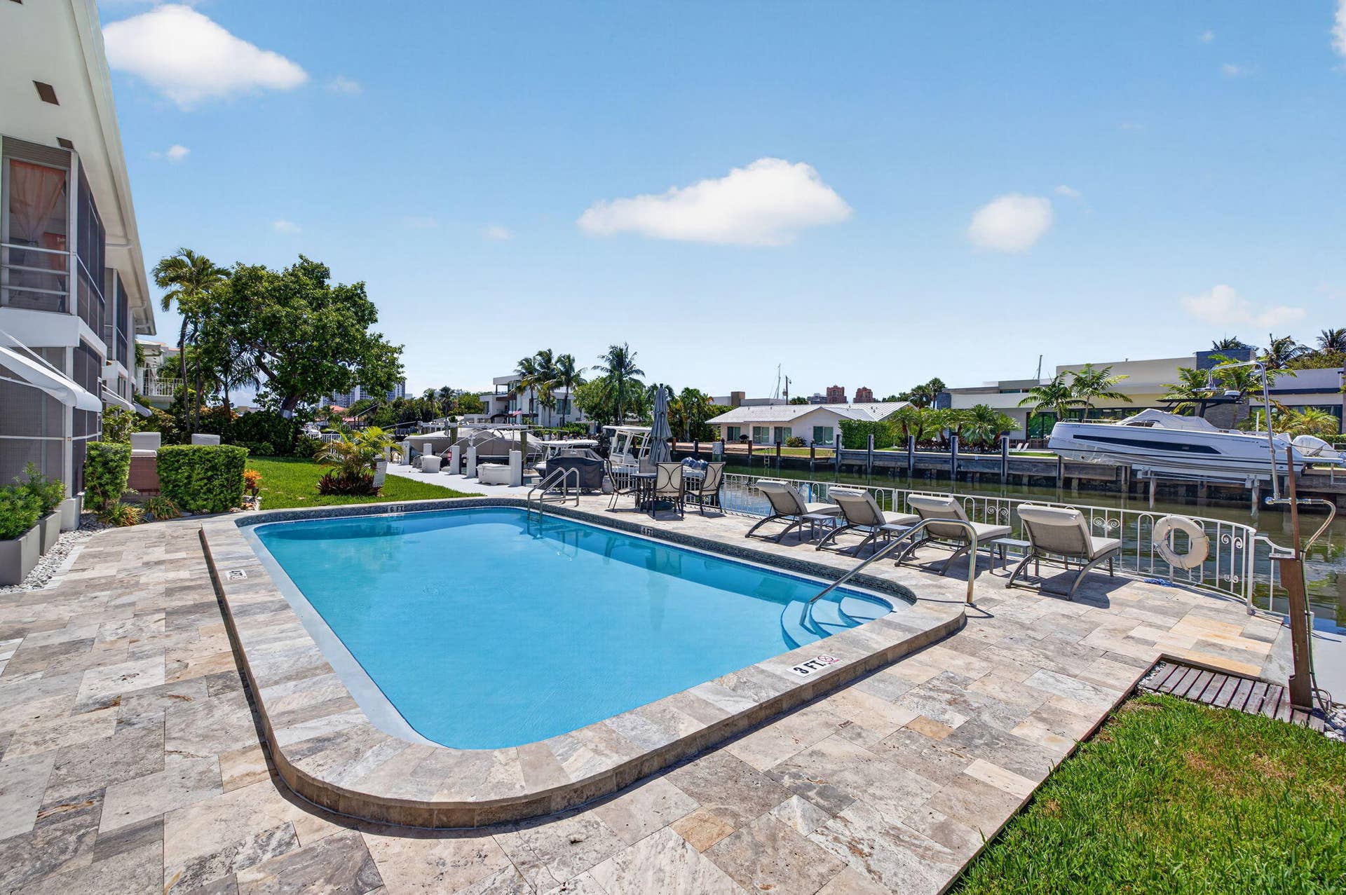 Waterfront property featuring in-ground swimming pool, and a paved pool deck