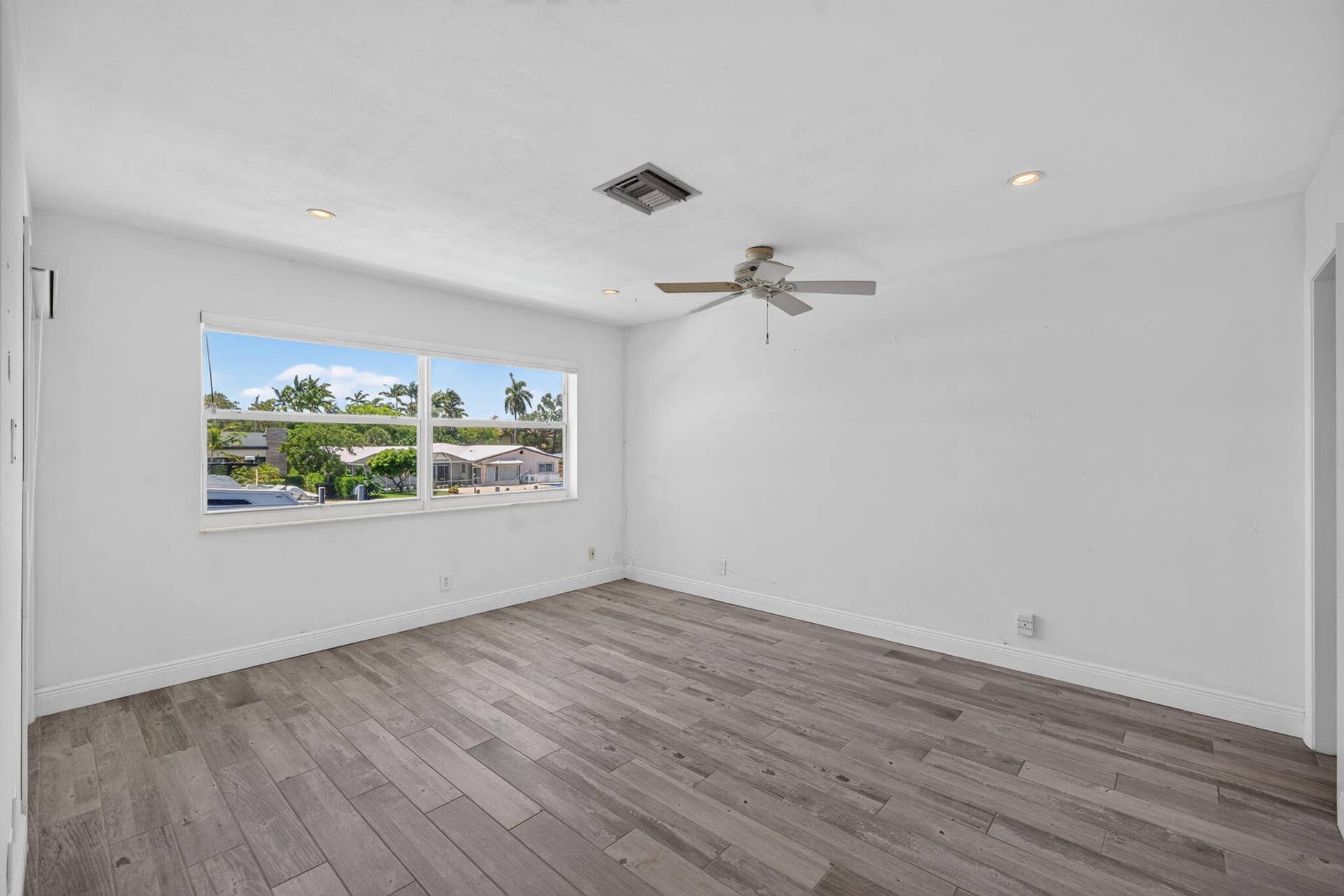Wood-finish flooring throughout, with a ceiling fan and recessed lighting