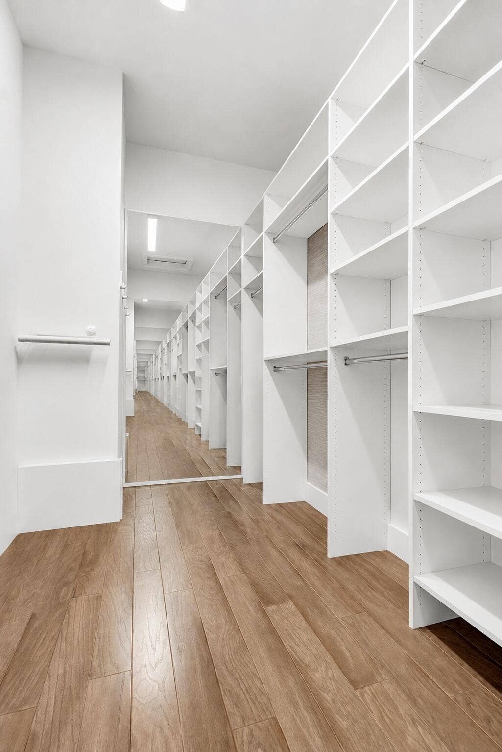9046 CHAUVET Way, Boca Raton, FL 33496 Walk-in closet featuring extensive built-in shelving, hanging rods, light wood-finish flooring, full-length mirror, and recessed lighting