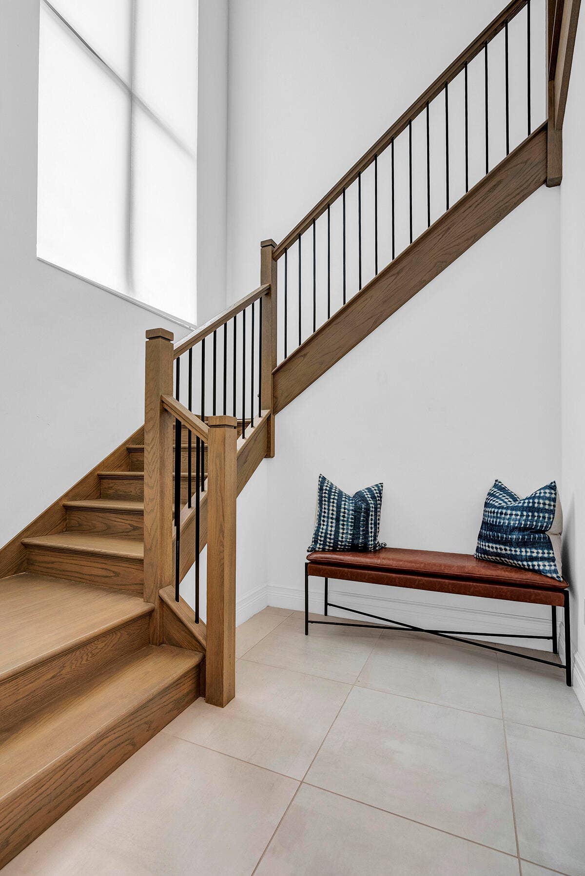 9046 CHAUVET Way, Boca Raton, FL 33496 Grand staircase featuring wood-finish treads and risers, a wood-finish handrail, and sleek black metal balusters