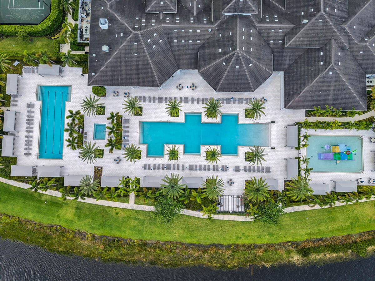 9046 CHAUVET Way, Boca Raton, FL 33496 Expansive aquatic facility featuring multiple pools, an aquatic play area, and extensive lounge seating