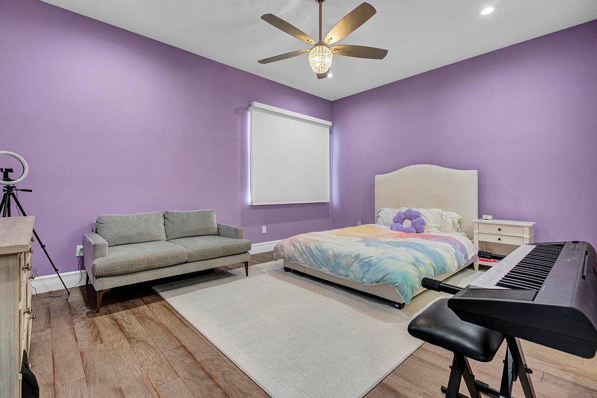 9046 CHAUVET Way, Boca Raton, FL 33496 Spacious room featuring wood-finish flooring, purple painted walls, and a large window with a roller shade