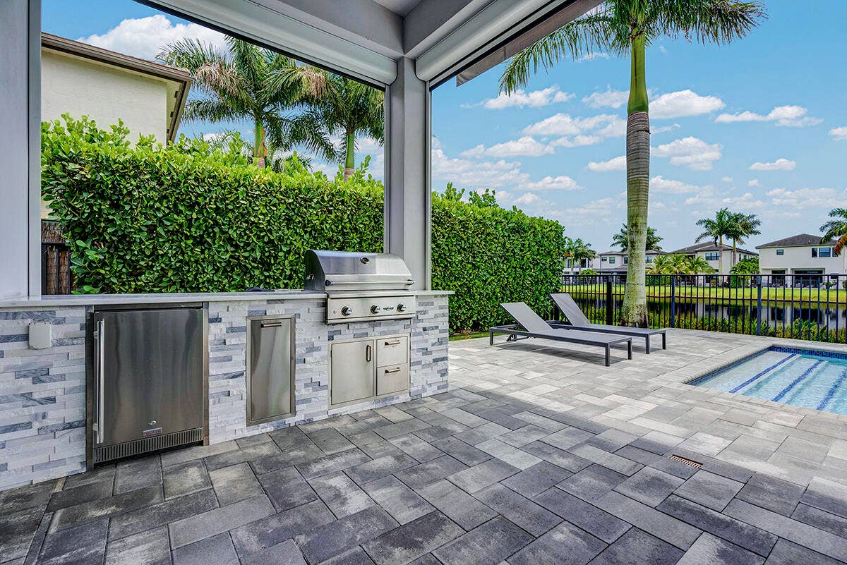 9046 CHAUVET Way, Boca Raton, FL 33496 Outdoor kitchen featuring a stainless steel grill, beverage refrigerator, and built-in cabinetry