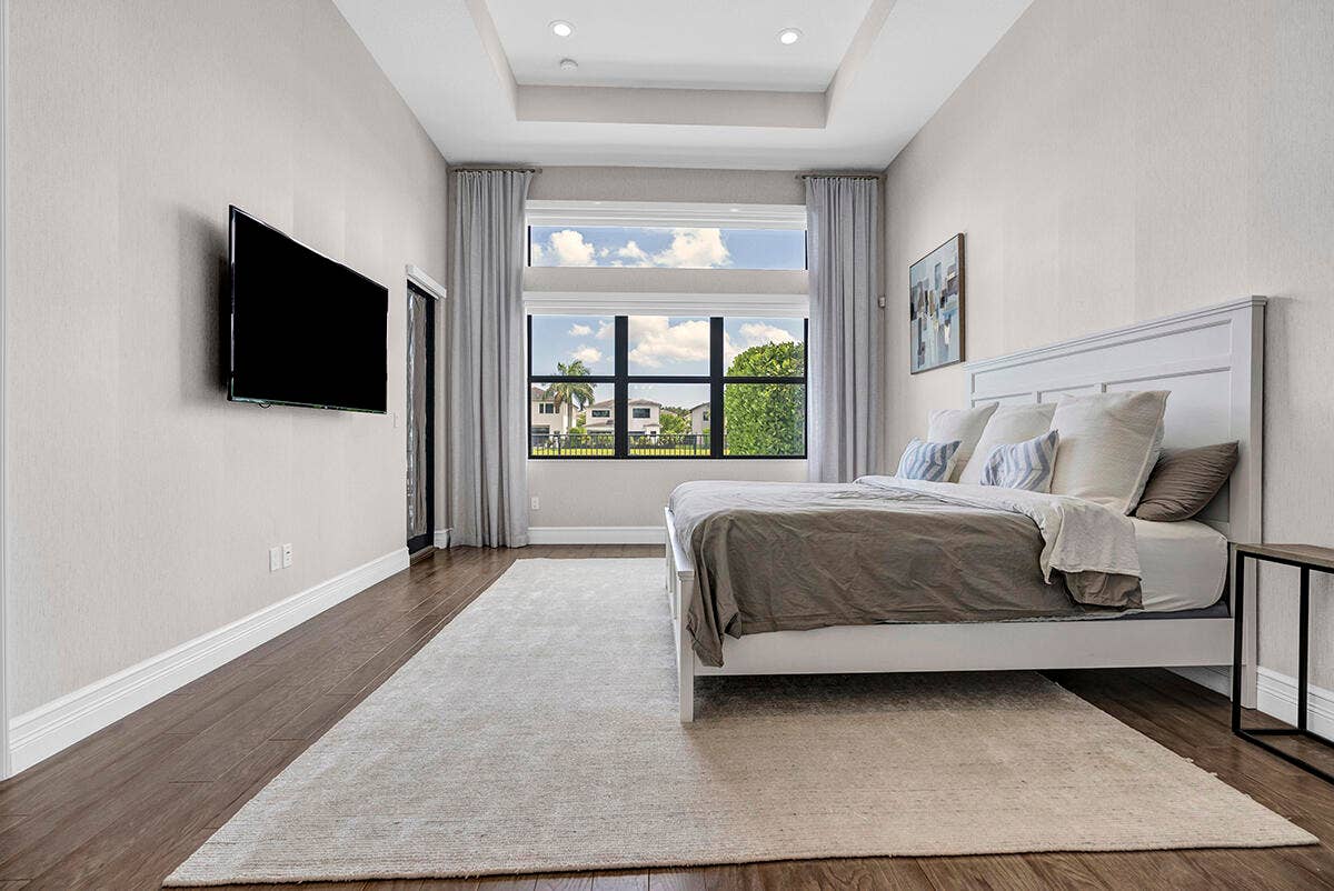 9046 CHAUVET Way, Boca Raton, FL 33496 Room featuring a tray ceiling with recessed lighting, large windows, wood-finish flooring, and a sliding glass door