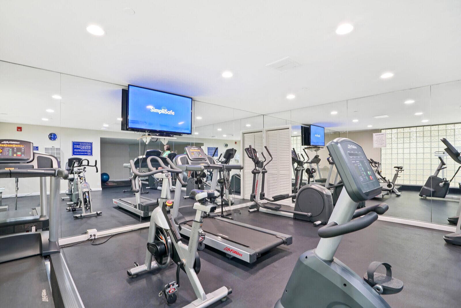 2 community fitness centers available for residents and includes cardio and strength-training equipment in a spacious mirrored workout environment.