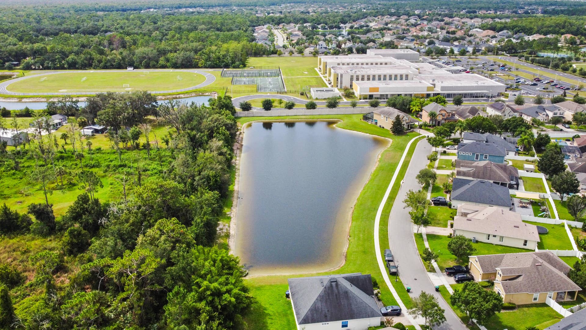 16437 TUDOR GROVE Drive, Orlando, FL 32828 Residential community with a neighborhood pond, paved streets, and landscaped yards