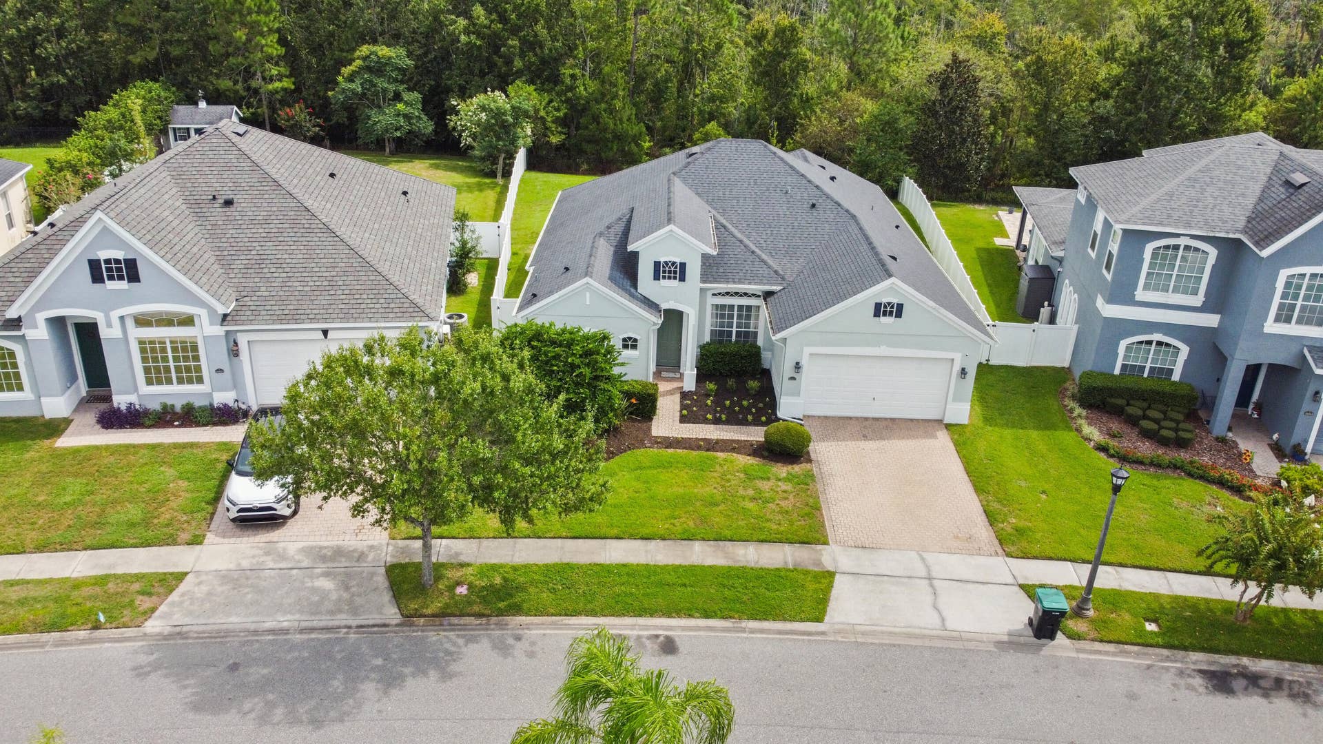 16437 TUDOR GROVE Drive, Orlando, FL 32828 Single-story residence featuring a light-toned exterior, an attached garage, a paved driveway, and a fenced backyard