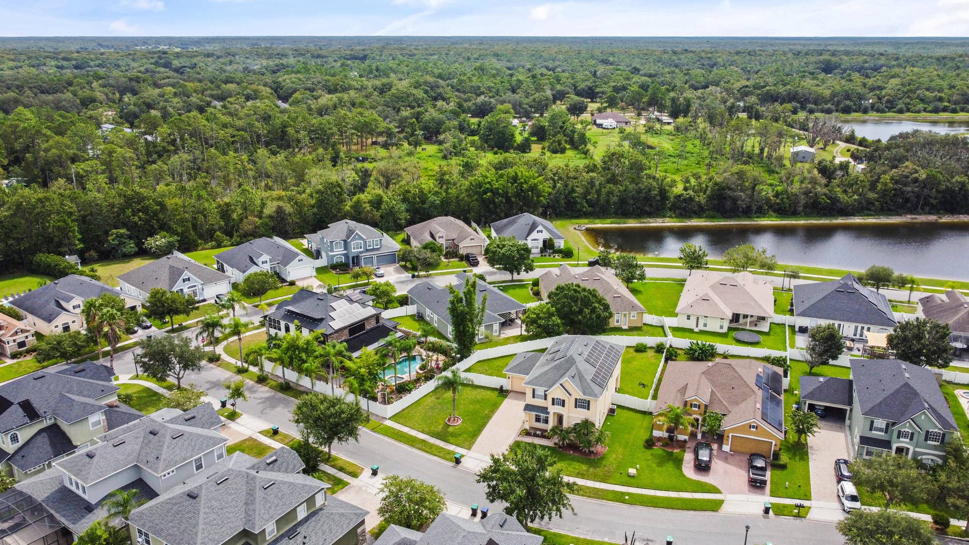 16437 TUDOR GROVE Drive, Orlando, FL 32828 Lakeside residential neighborhood featuring multiple single-family homes, mature landscaping, and established infrastructure