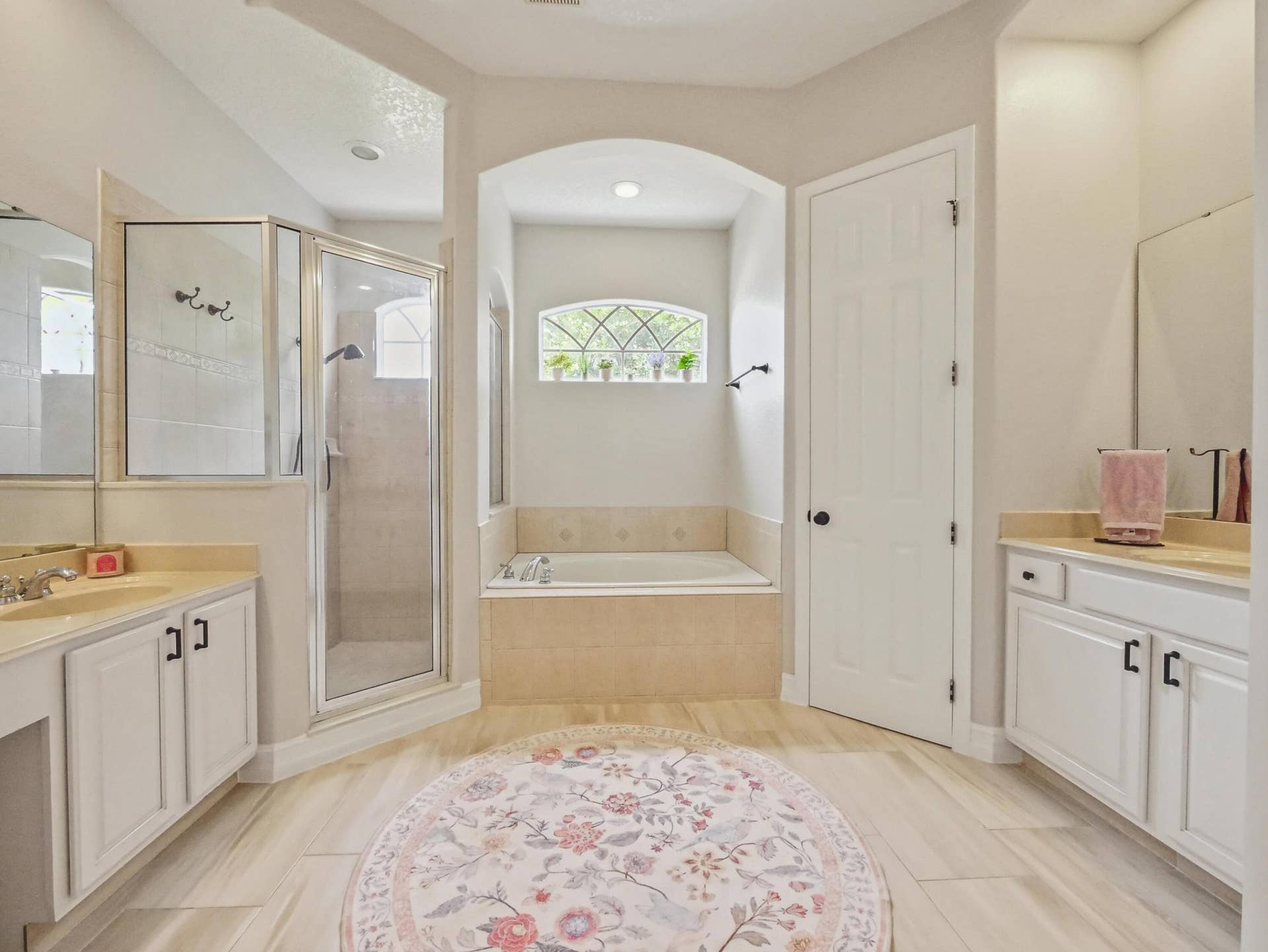 16437 TUDOR GROVE Drive, Orlando, FL 32828 Dual vanities with integrated sinks, a glass-enclosed shower, a built-in soaking tub, and tile flooring
