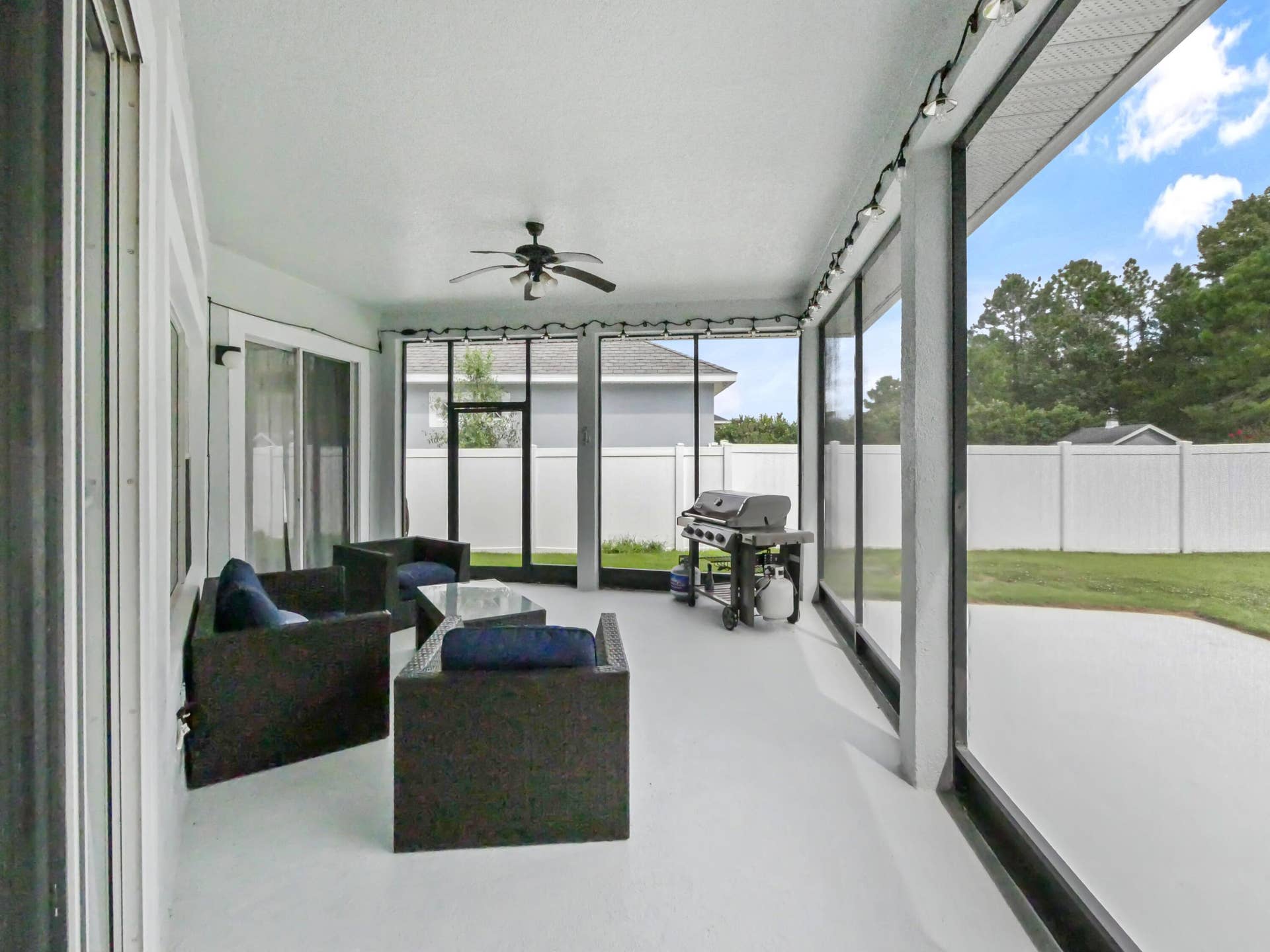 16437 TUDOR GROVE Drive, Orlando, FL 32828 Screened porch with ceiling fan, sliding glass doors, and concrete flooring