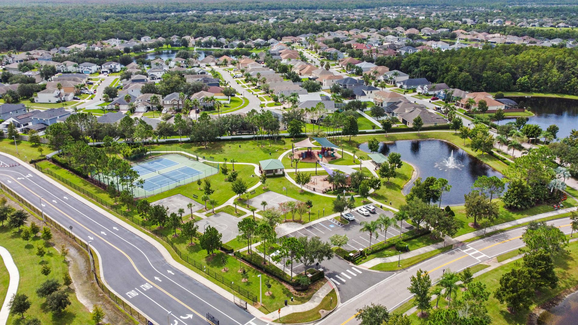 16437 TUDOR GROVE Drive, Orlando, FL 32828 Community green space with tennis courts, a playground, and a tranquil pond with a fountain feature