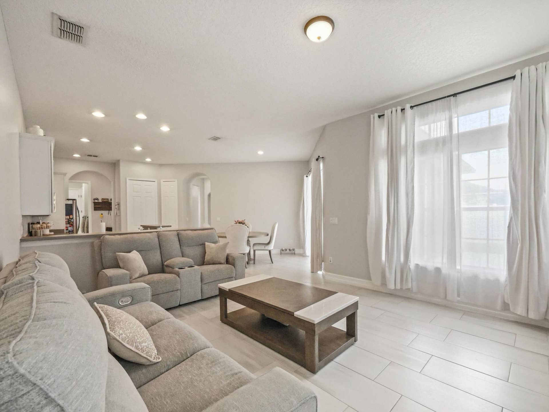 16437 TUDOR GROVE Drive, Orlando, FL 32828 Recessed lighting, large windows, light-toned tile flooring, and arched doorways