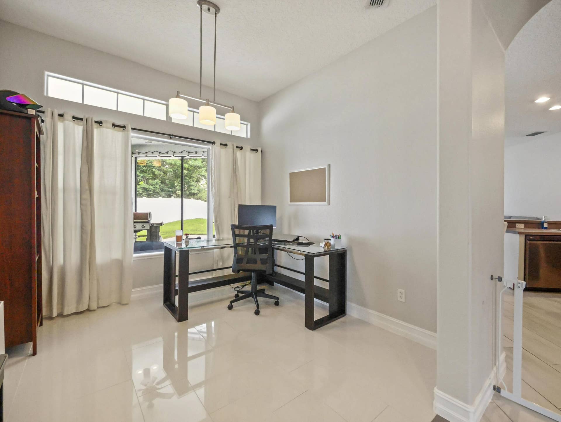 16437 TUDOR GROVE Drive, Orlando, FL 32828 High ceilings, transom windows, and a modern linear pendant light fixture illuminate this versatile space