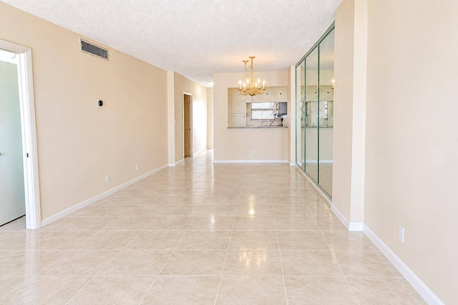 Dining room and living room, furniture removed. Carpet removed, tile added. DIGITALLY ENHANCED
