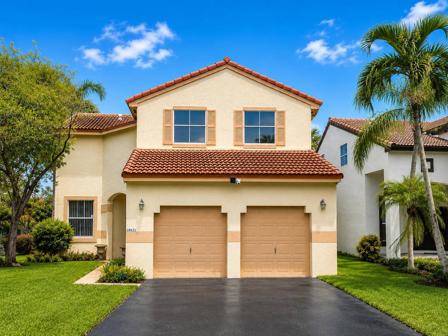 18431 NW 18TH Street, Pembroke Pines, FL 33029 Stucco exterior with a tile roof, dual garage doors, decorative shutters, and mature landscaping