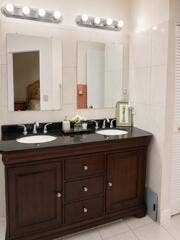 18431 NW 18TH Street, Pembroke Pines, FL 33029 Dual vanity with dark wood-finish cabinetry, integrated sinks, and polished chrome faucets