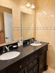 18431 NW 18TH Street, Pembroke Pines, FL 33029 Dual oval undermount sinks with chrome-finish faucets, dark wood-finish vanity with cabinet storage, and a dark countertop