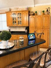 18431 NW 18TH Street, Pembroke Pines, FL 33029 Kitchen featuring wood cabinetry, a built-in pantry, and a breakfast bar with a dark countertop