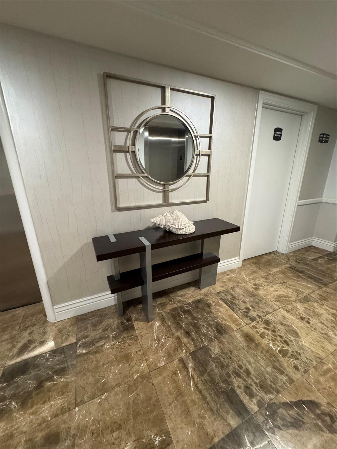 3800 GALT OCEAN Drive, #1508, Fort Lauderdale, Fort Lauderdale, FL 33308 Marbled tile flooring, textured wall covering, decorative wall mirror, and a wood-finish console table